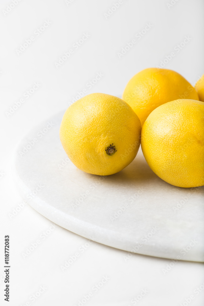 whole piece, fresh lemons over marble cutting board, close up, vertical