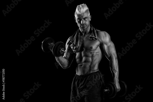 Closeup of a handsome power athletic man bodybuilder doing exerc © romanolebedev