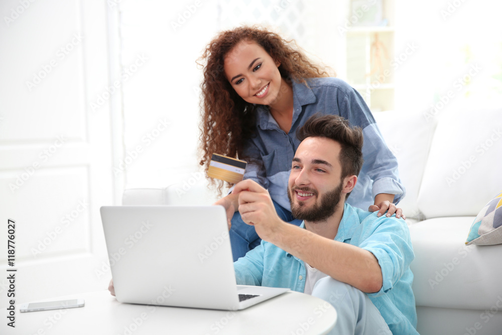 Young man and woman using credit card and laptop for online shopping Young man and woman using credit card and laptop for online shopping