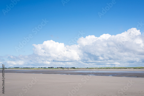 hard packed sand beach in Long Beach peninsula shoreline, Washington. houses around the beach and beautiful clouds in open sky. landscape © misszin