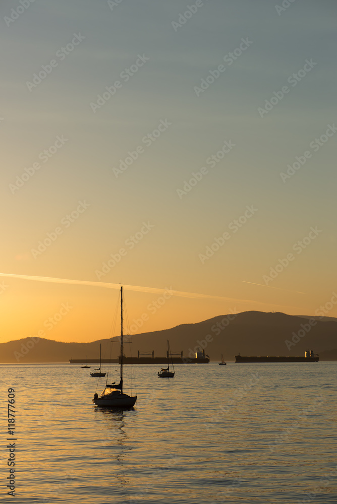 sailboats and freight ships at sunset in English Bay, Vancouver, BC