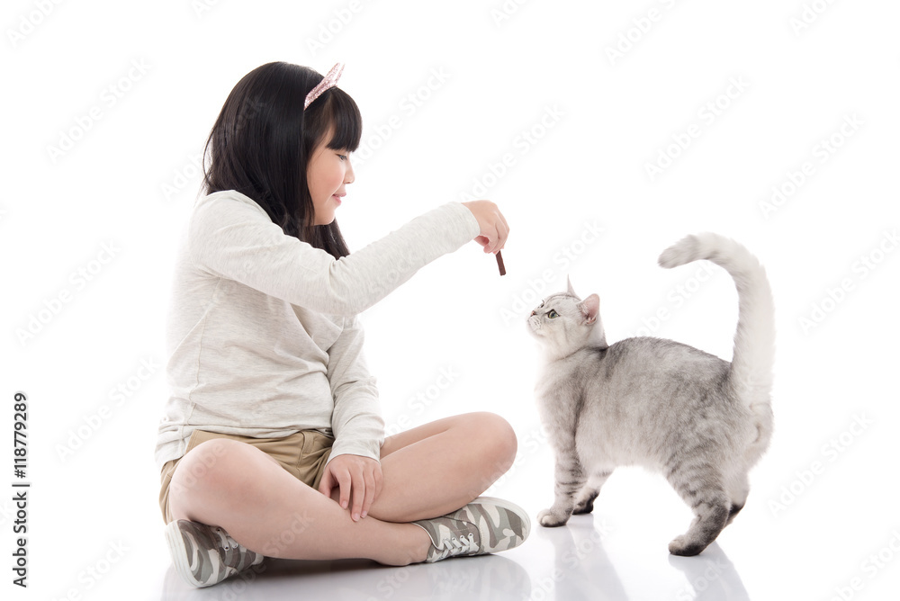 Beautiful Asian girl feeding snack to cute kitten on
