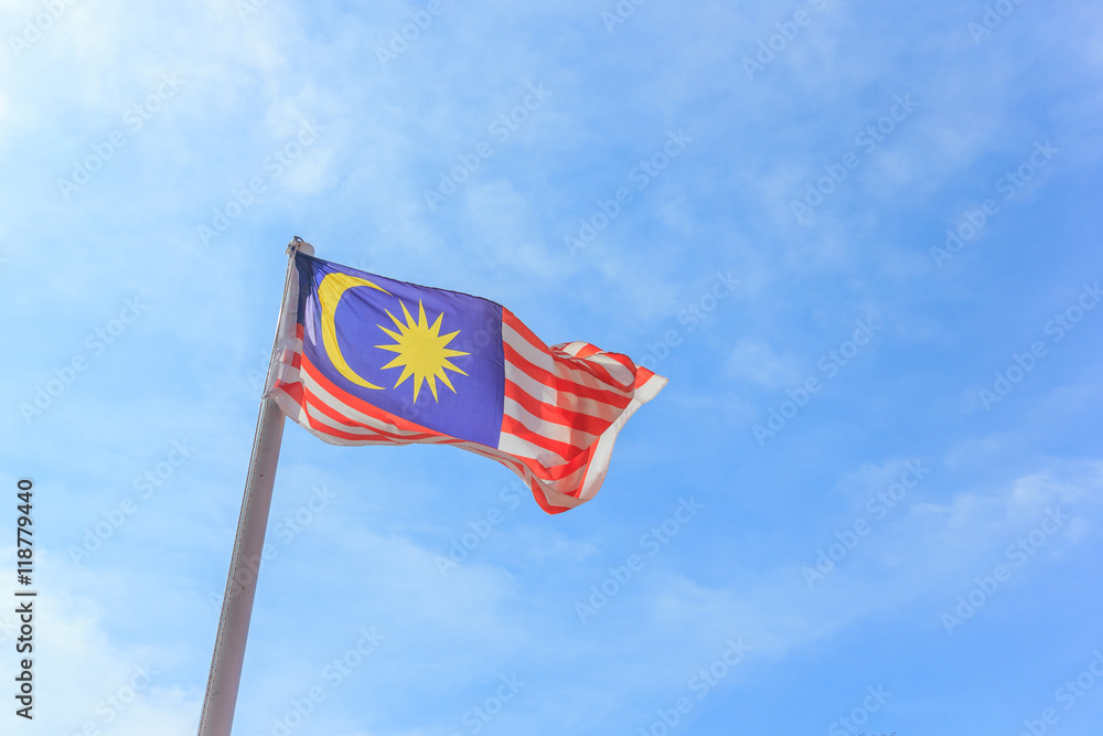 Malaysian national flag on a pole against blue sky Malaysian national flag on a pole against blue sky