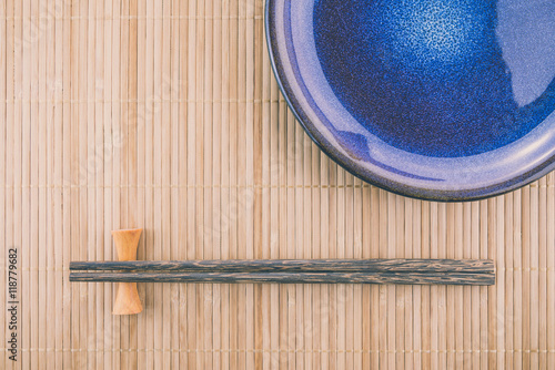 Flat lay handmade dish on Japanese mat background with sushi chopsticks