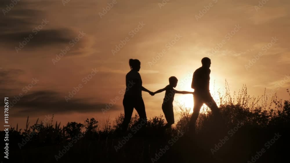Silhouette, happy children with mother and father, family at sunset, summertime Silhouette, happy children with mother and father, family at sunset, summertime