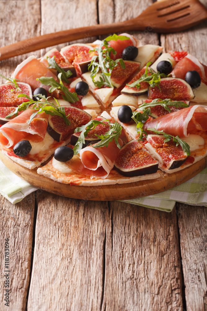 pizza with figs, ham, arugula, olives and mozzarella cheese. vertical
