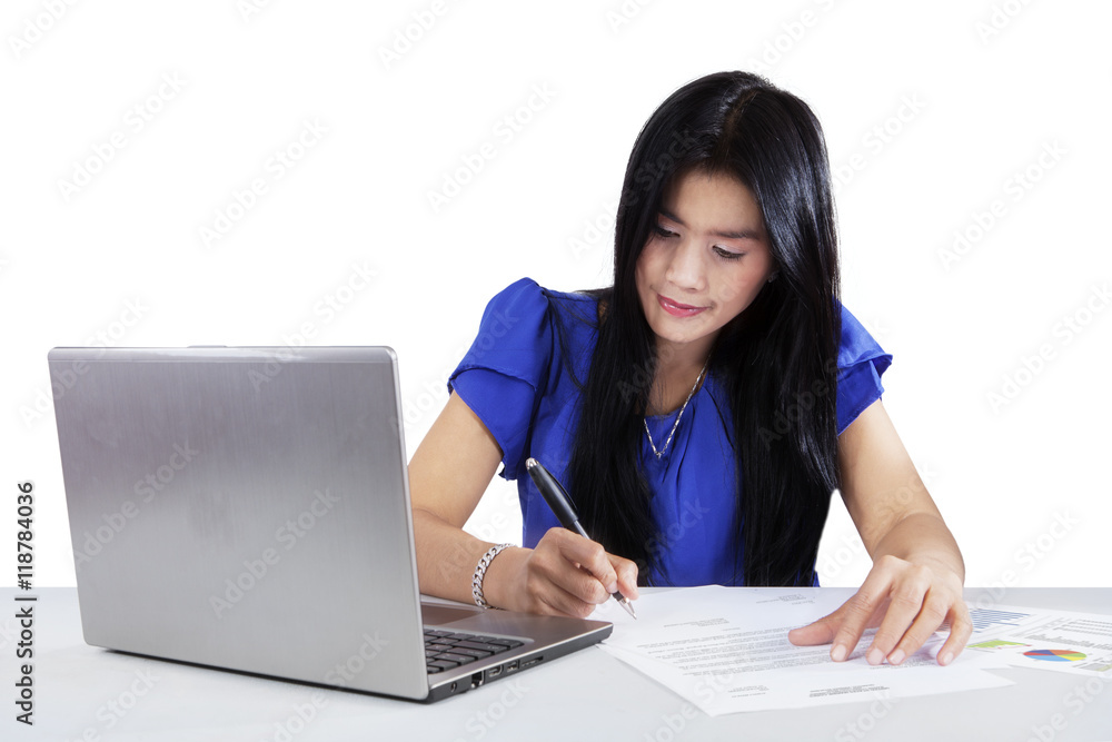 Businesswoman writing on paperwork Businesswoman writing on paperwork