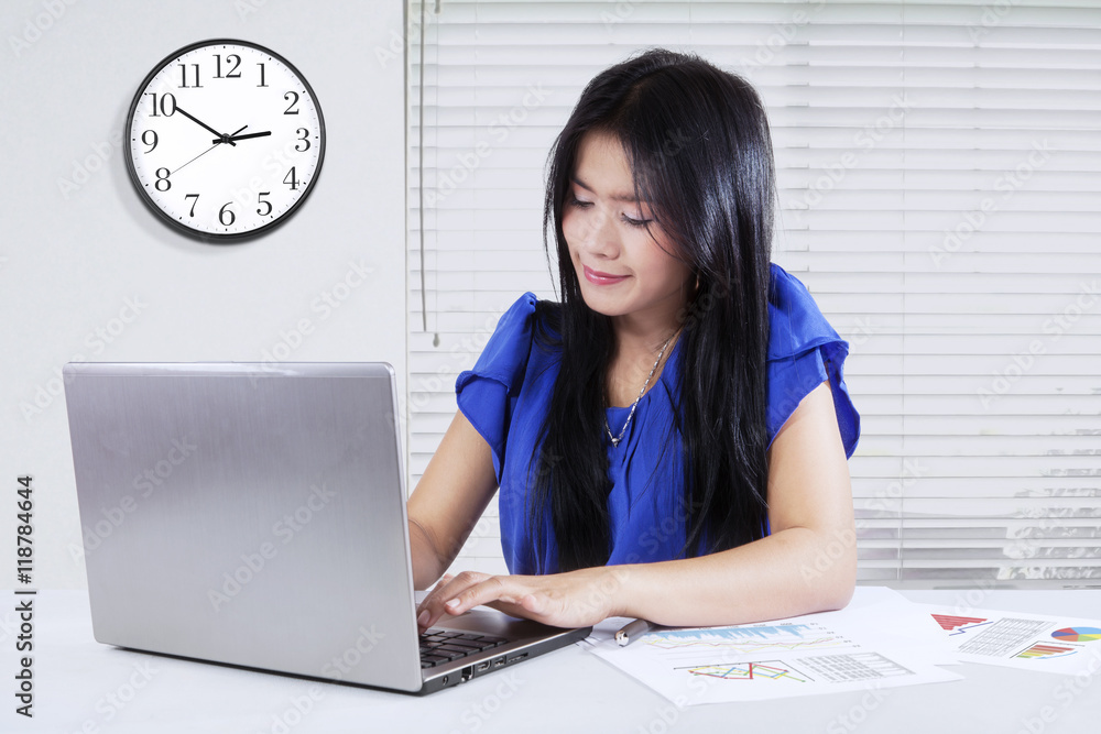 Female worker with paperwork and laptop Female worker with paperwork and laptop