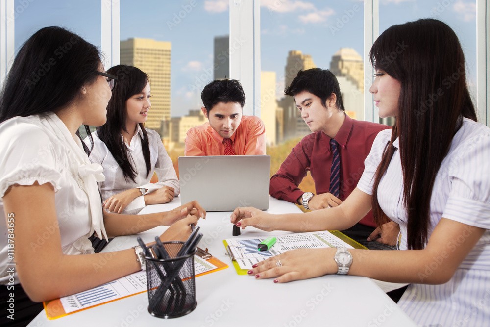 Fototapeta premium Five workers discussing in the meeting