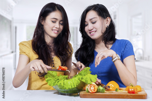 Two woman preparing salad together