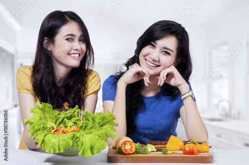 Two woman shows a bowl of salad