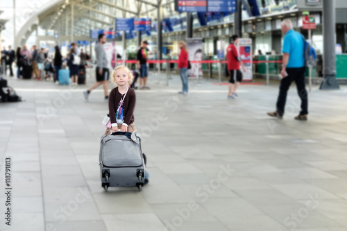 Kleines Mädchen mit koffer im flughafen
