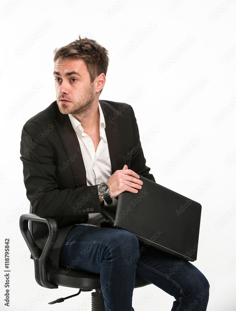 Scared and worried manager. / Tired manager sitting on chair covers laptop so that you can not see what he was working with fright looking at right. Studio, white background. Scared and worried manager. / Tired manager sitting on chair covers laptop so that you can not see what he was working with fright looking at right. Studio, white background.