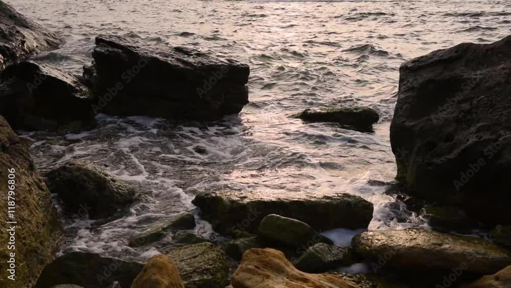 Sea surf at the coast, sunny water with white foam splashing to the pebble beach, natural summer vacation relaxing concept Sea surf at the coast, sunny water with white foam splashing to the pebble beach, natural summer vacation relaxing concept
