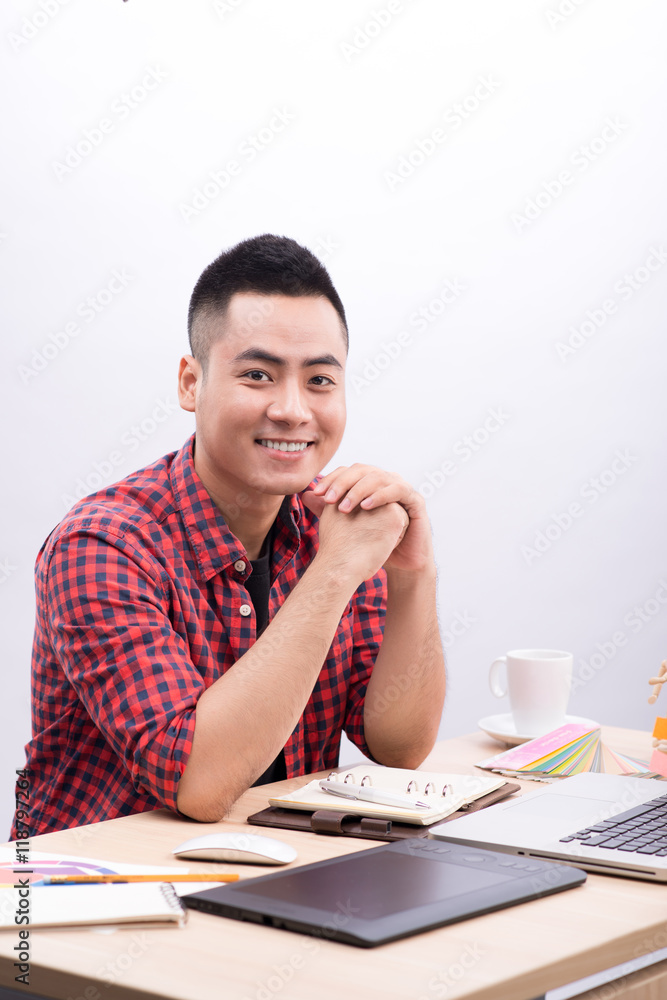 Portrait of young male graphic designer at desk. Portrait of young male graphic designer at desk.