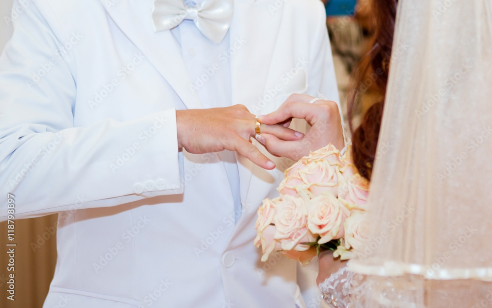 Bride puts the ring on the bridegroom's finger in the wedding day Bride puts the ring on the bridegroom's finger in the wedding day