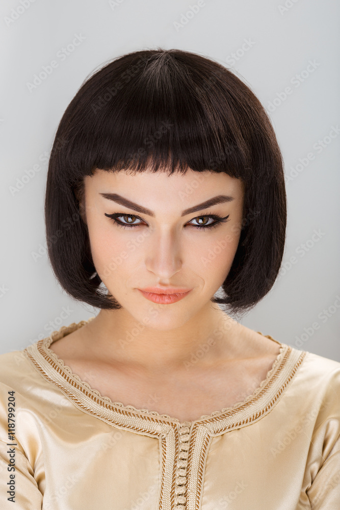 Serious andgy girl with Cleopatra's make-up and haircut posing in studio Serious andgy girl with Cleopatra's make-up and haircut posing in studio