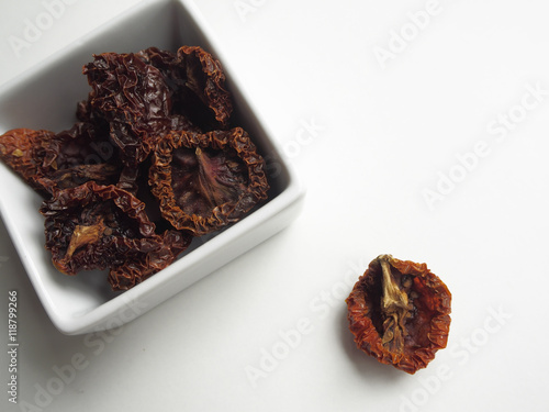 Dried tomatoes in container on white backgroundo photo