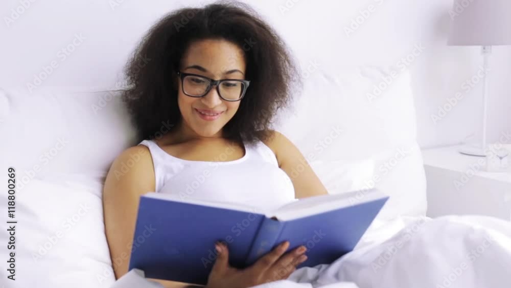african woman reading book in bed at home bedroom african woman reading book in bed at home bedroom