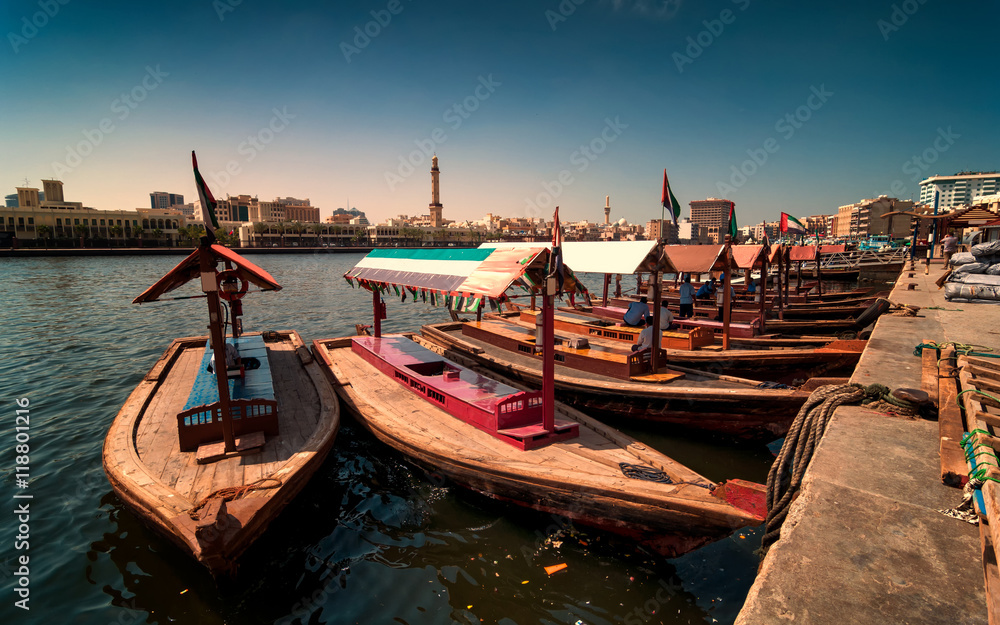 Naklejka premium Traditional Abra taxi boats in Dubai creek - Deira during sunny day, Dubai Deira, United Arab Emirates