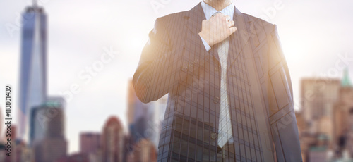 Photography Double exposure of a businessman adjusting his necktie in front of a big city
