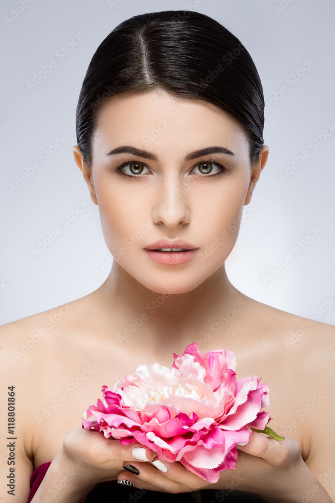 Obraz premium Beautiful girl with naked shoulders holding flower