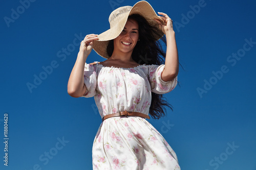 Fotografía woman catched summer hat blowed by wind