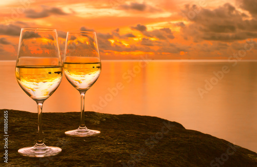 Pair of wine glasses against a beautiful tropical sunset. 
