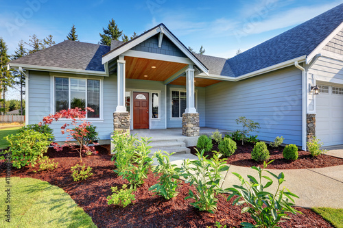 Light blue siding house . Porch with stone base columns.