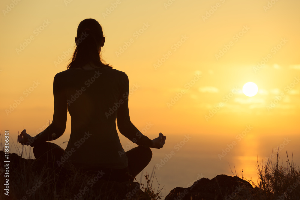 Woman meditating in a beautiful outdoor setting. 