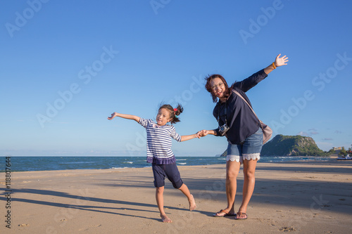 Mom and daughter enjoy walking on beach, Mom and daughter relaxing on beach