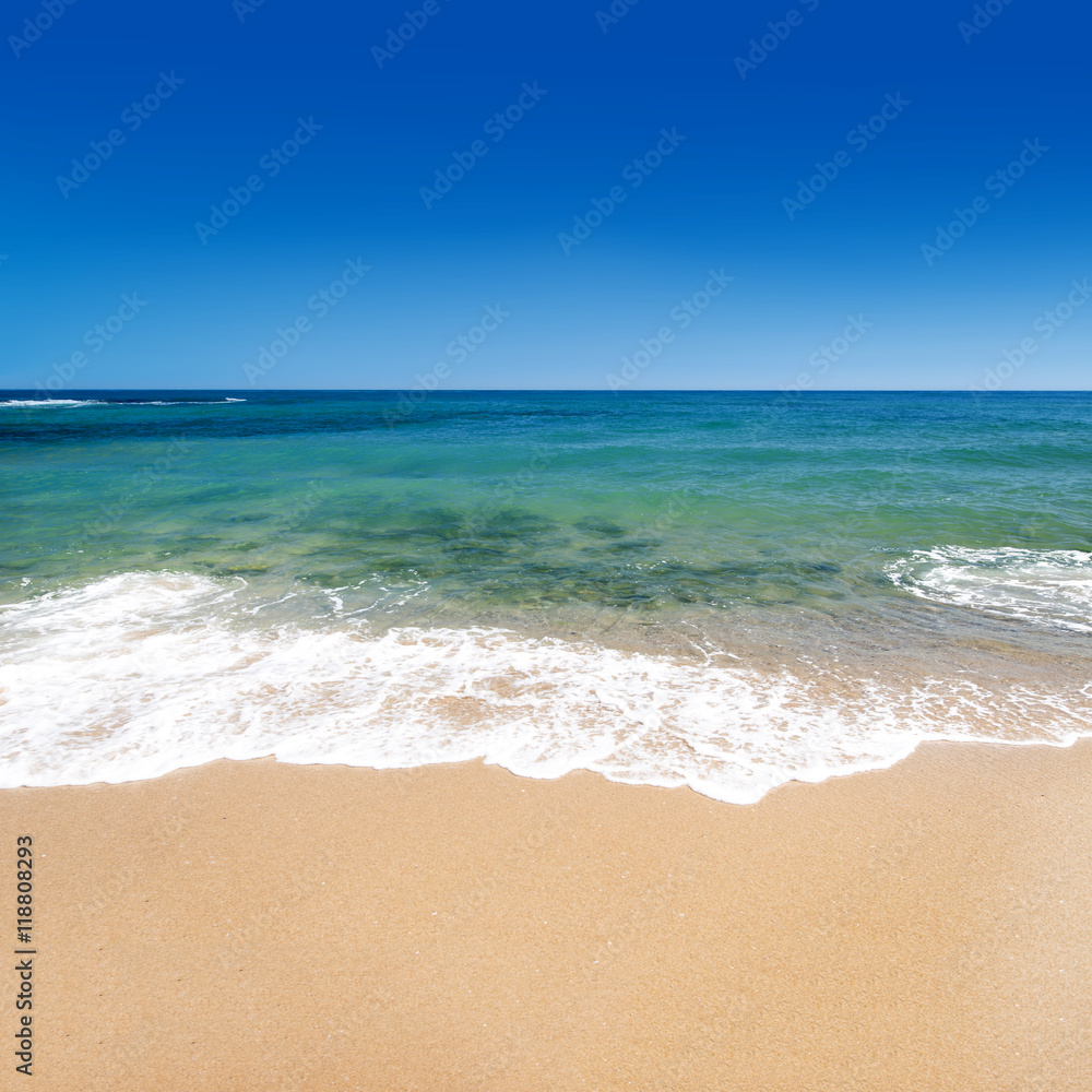 Calm sea with golden sand and blue sky