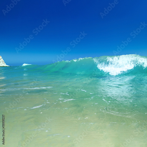Sea wave with foam and blue sky.