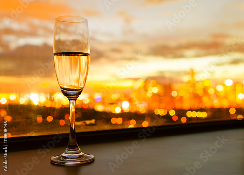 Glass of champaign against a beautiful sunset in the city.
