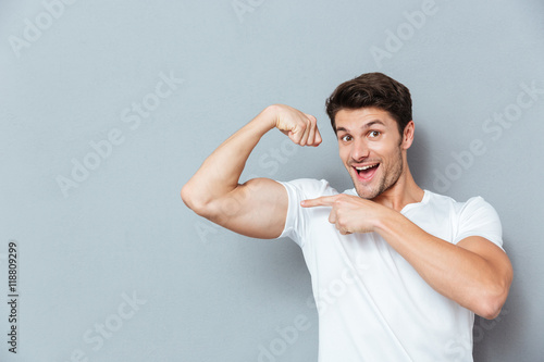 Stampa su tela Smiling man pointing on his biceps