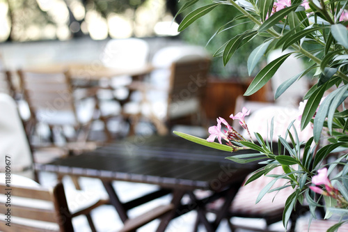 Wood table, chaires  and flowers at the restaurant cafe bistro terrace photo