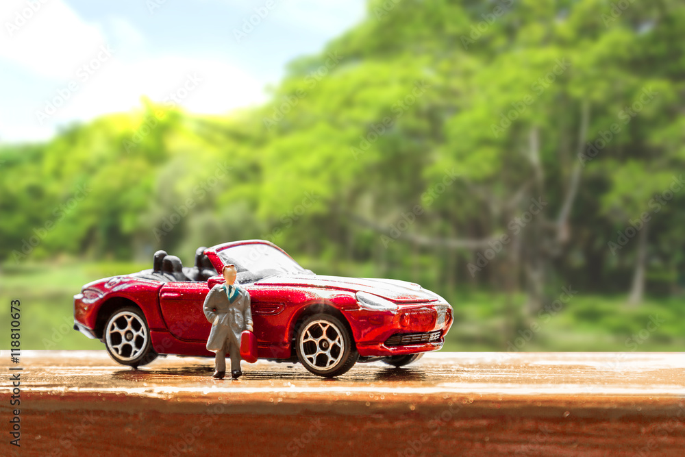 Business figure and toy car with nature background