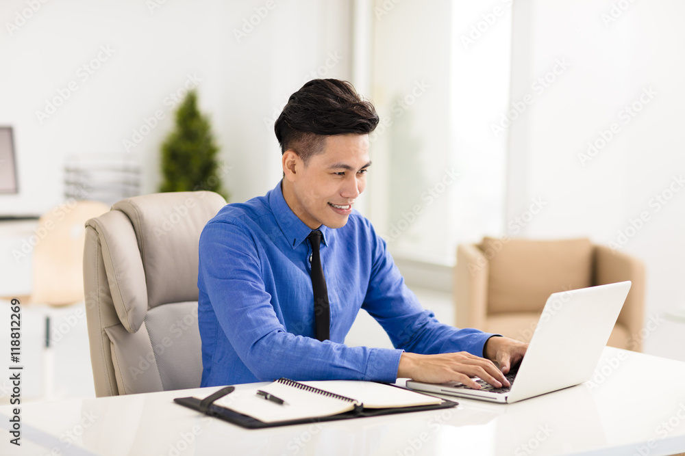 young smiling business man working in office young smiling business man working in office