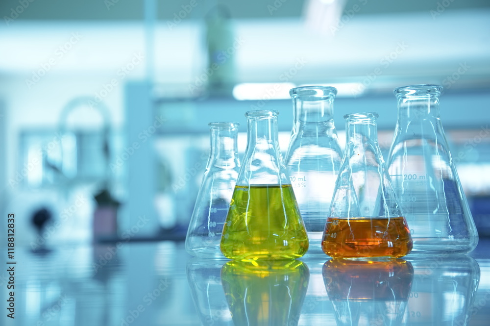 flask glassware with orange and yellow solution in blue science flask glassware with orange and yellow solution in blue science