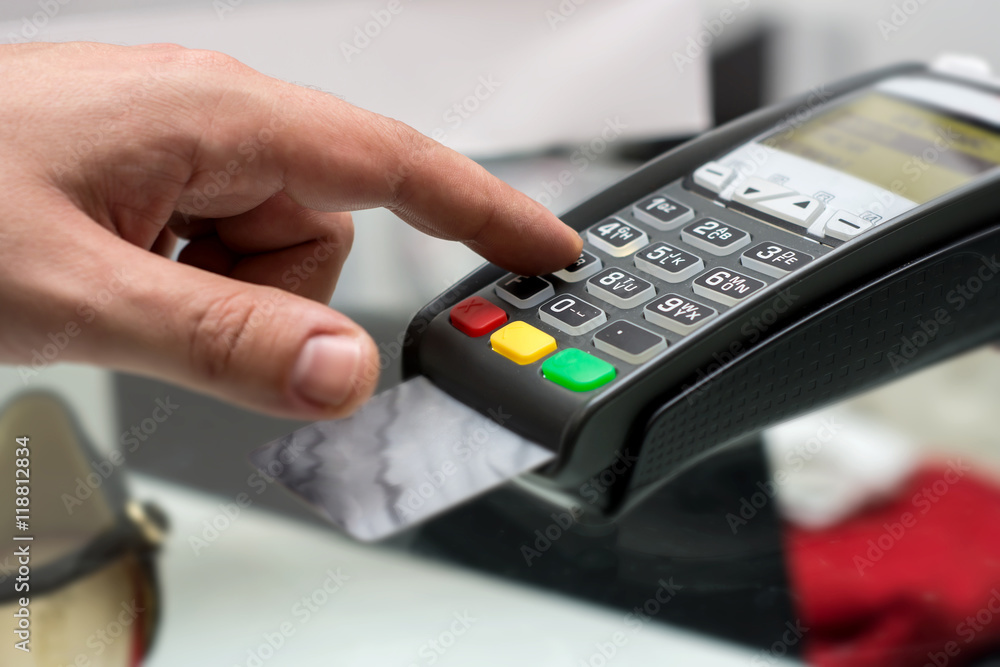 Credit or debit card password payment. Customer hand is entering pin Credit or debit card password payment. Customer hand is entering pin