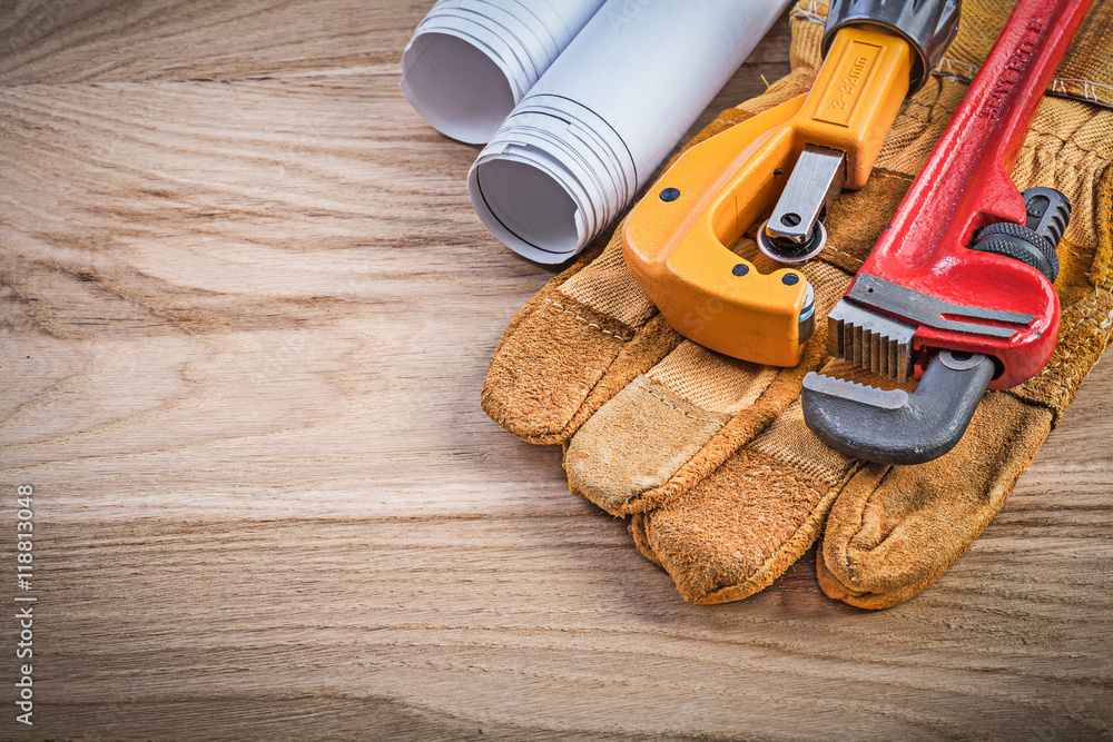 Construction plans safety gloves monkey wrench pipe cutter on wo Construction plans safety gloves monkey wrench pipe cutter on wo