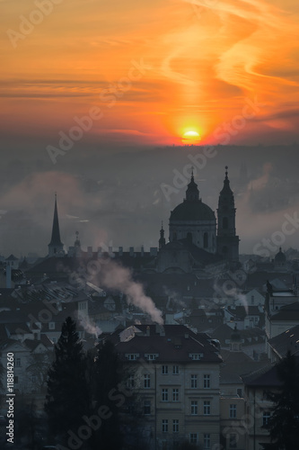 Beautiful St. Nicolas church during foggy sunrise and amazing cloudy sky, Prague, Czech republic