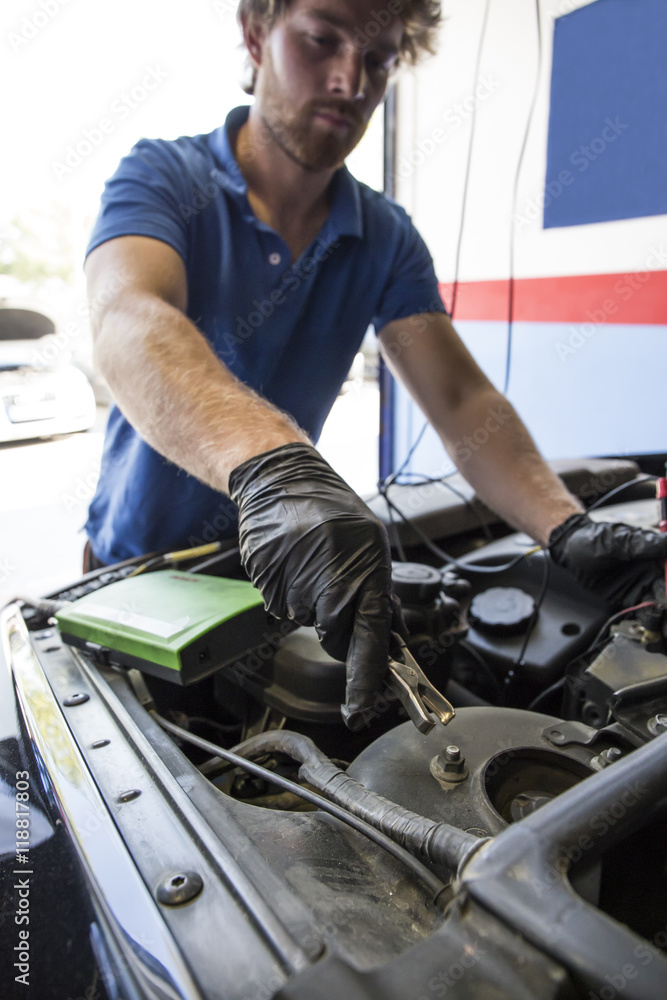 Mechanic placing a battery clip in a car Mechanic placing a battery clip in a car