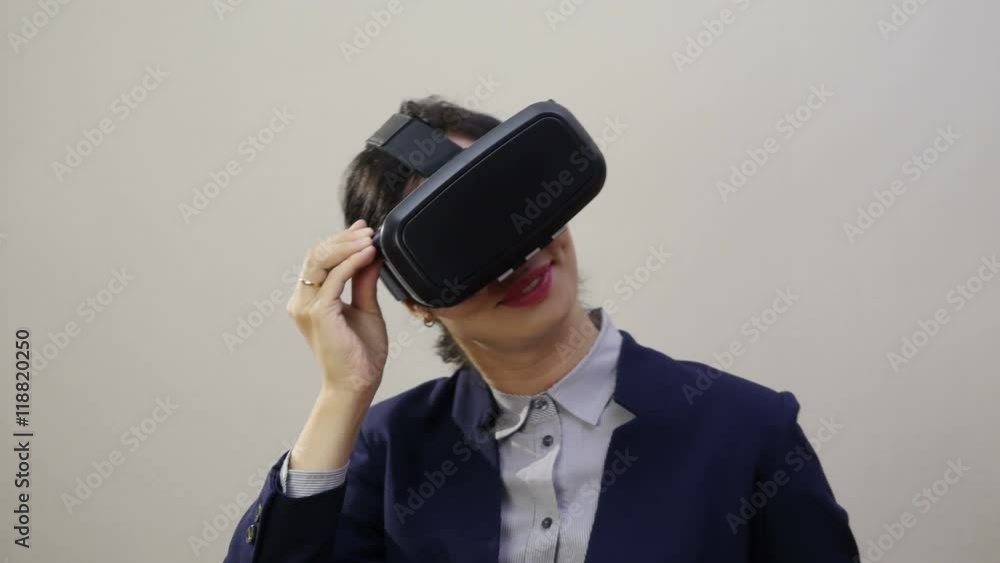 Woman uses a head mounted display. Woman in a virtual reality mask looks around. Woman uses a head mounted display. Woman in a virtual reality mask looks around.