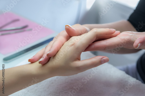 Woman hands in a nail salon receiving a hand massage by a beaut