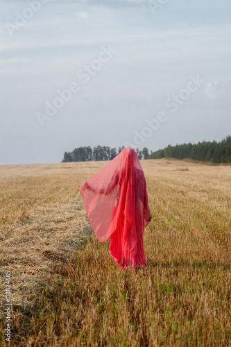 Muslim woman in the field  wearing a red headscarf