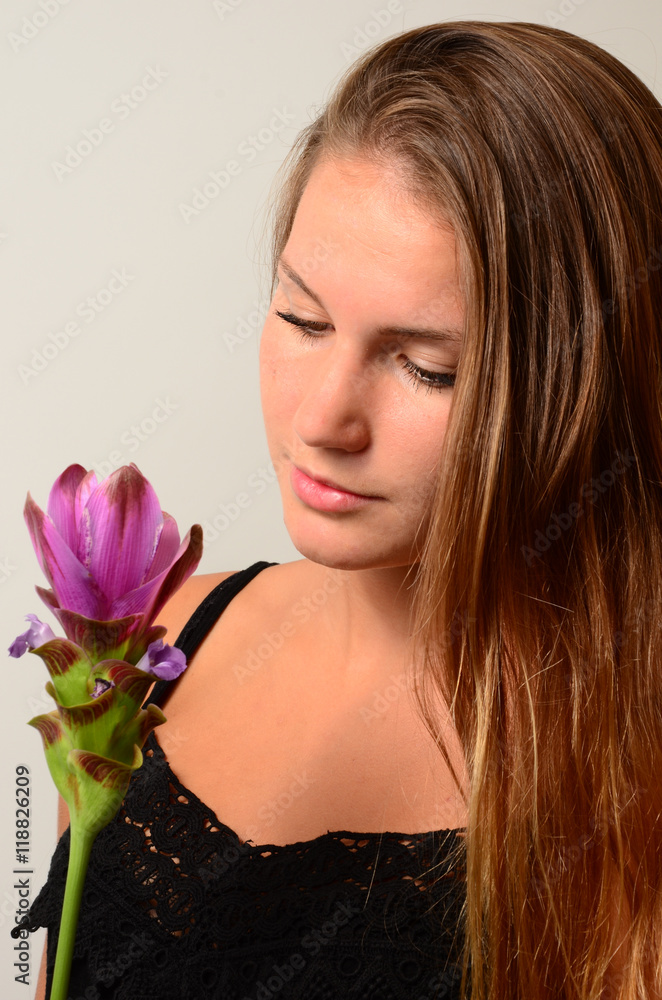 junge Frau mit Blume nachdenklich