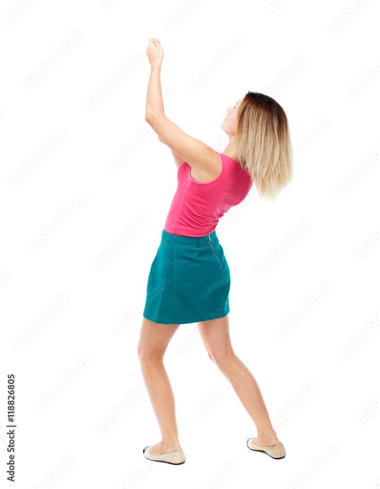 back view of standing girl pulling a rope from the top or cling to something. girl watching. Rear view people collection. backside view of person. Isolated over white background. Blonde in a red back view of standing girl pulling a rope from the top or cling to something. girl watching. Rear view people collection. backside view of person. Isolated over white background. Blonde in a red