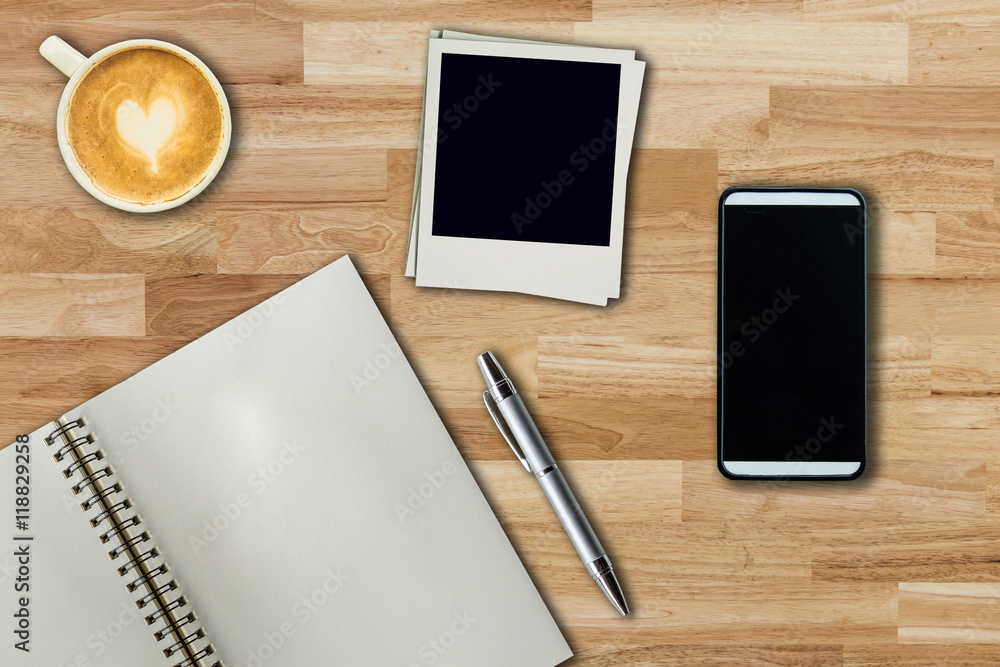 Mobile phone, notebook pen, photo frame and coffee cup on office Mobile phone, notebook pen, photo frame and coffee cup on office