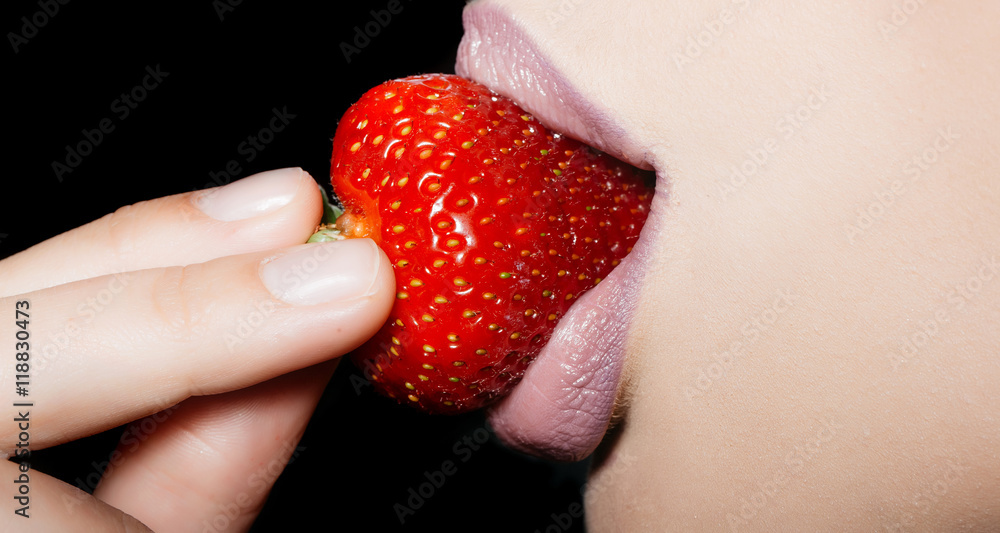 Obraz premium female lips eating red strawberry